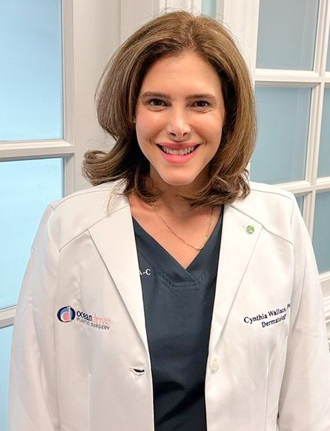 Doctor in a white coat smiling at camera.