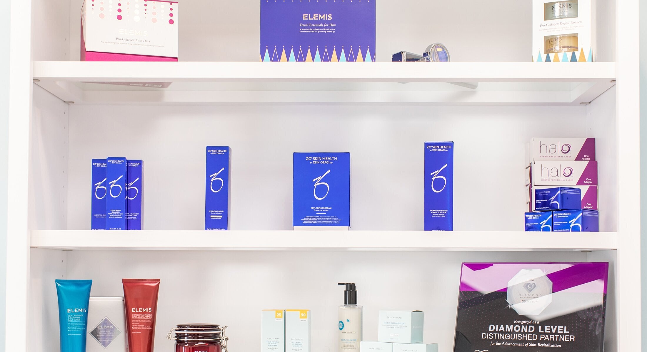 Skincare products displayed on white shelves.